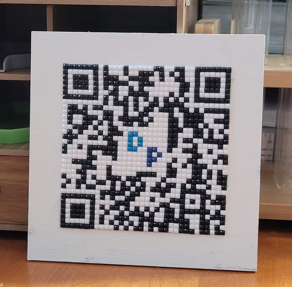 A QR code diamond painted onto a blank square of wood. It will direct people to my Diamond Painting Deals and Discounts group on Facebook.